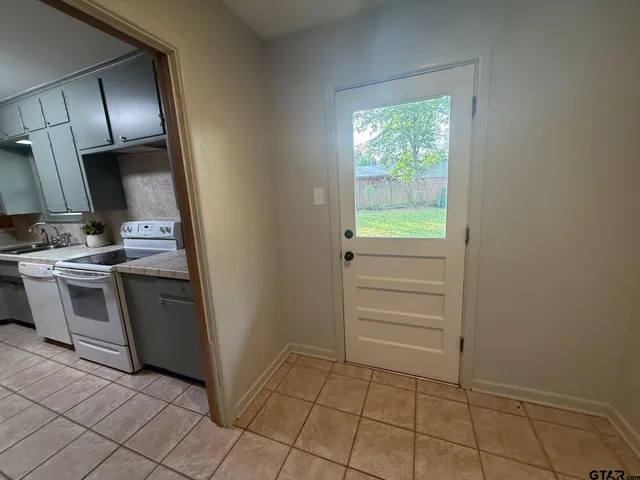 a view of an empty room with window and cabinet