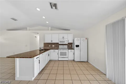a kitchen with a sink a stove top oven and cabinets