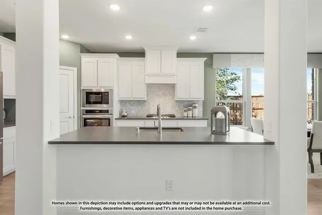 a kitchen with stainless steel appliances granite countertop a sink and a refrigerator