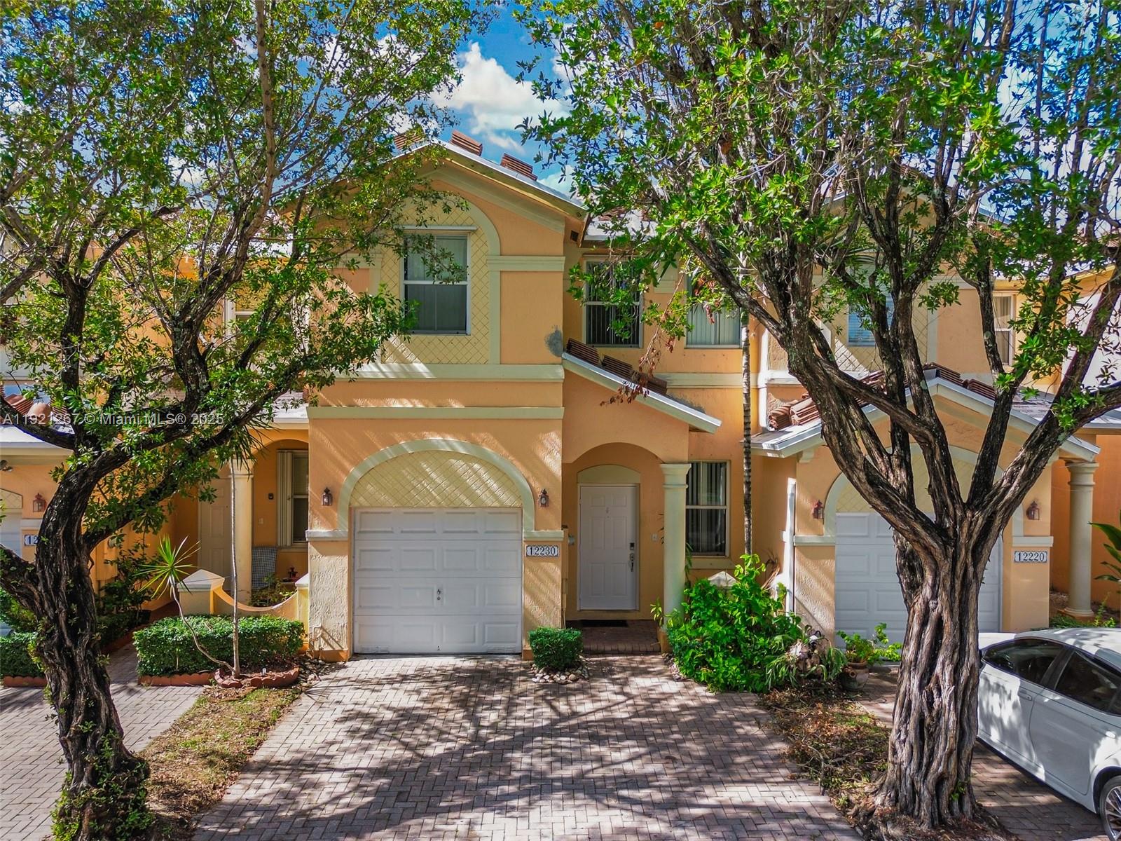 12230 Southwest 123rd Pass Miami, FL 33186 - Photo 27 of 65 a view of a white house with a large tree and next to a yard