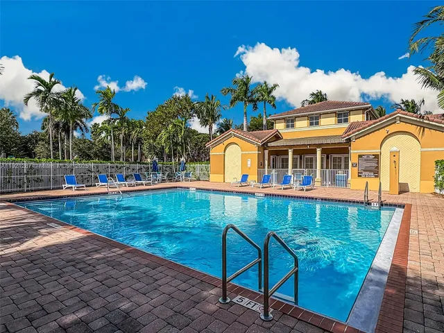 a view of a house with pool and a yard