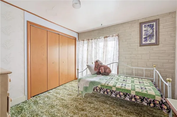 a bed room with a bed and a painting on the wall