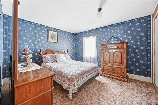 a bedroom with a bed and a dresser with the shoe rack