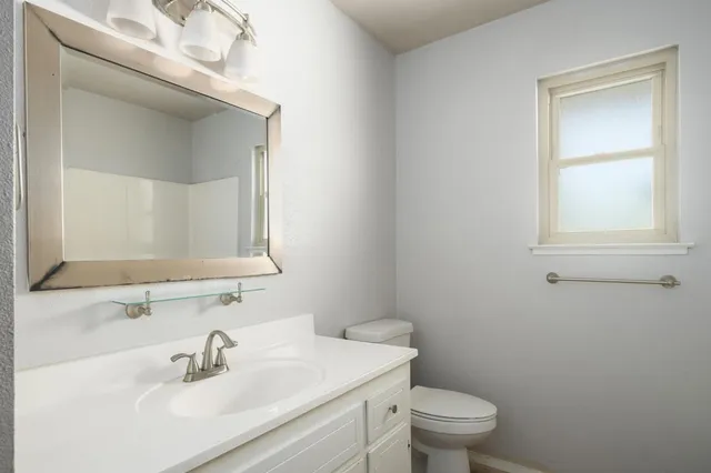 a bathroom with a sink a toilet and a mirror