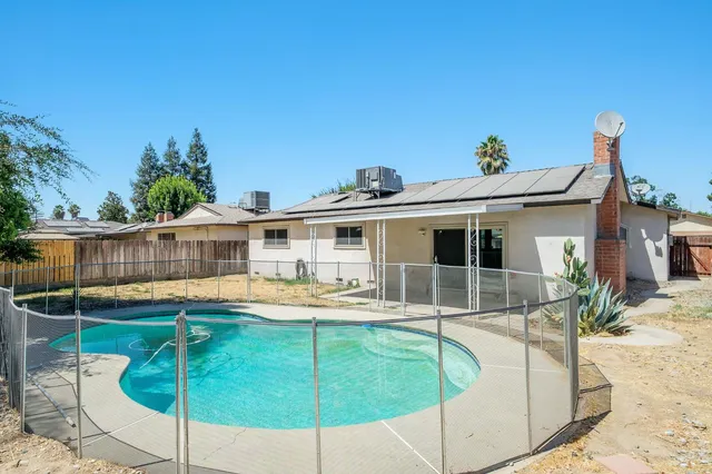 a view of a house with swimming pool and sitting area