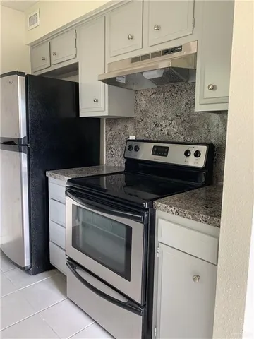a stove top oven sitting inside of a kitchen