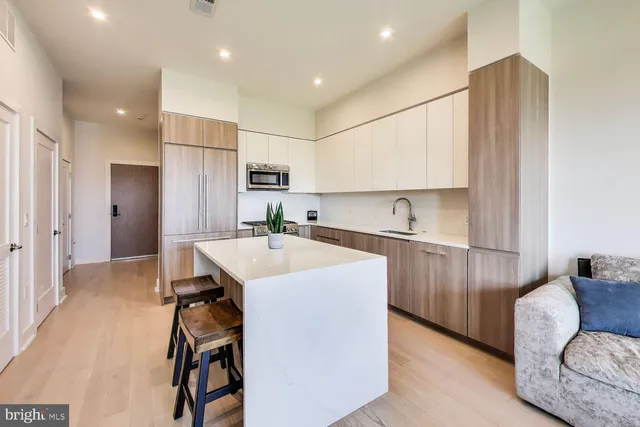 a kitchen with kitchen island a sink stove and refrigerator
