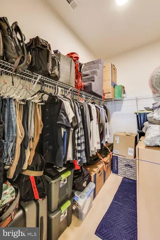 a view of walk in closet with clothes and shoes