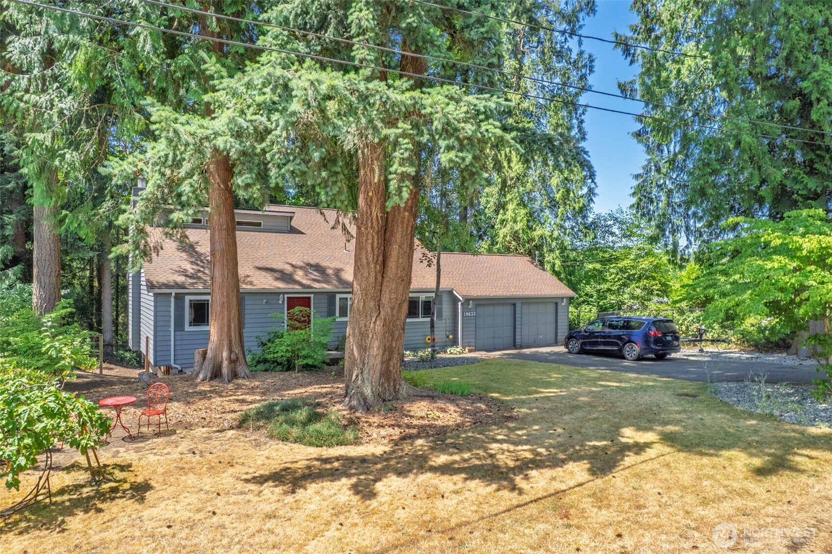 a front view of a house with a garden and tree