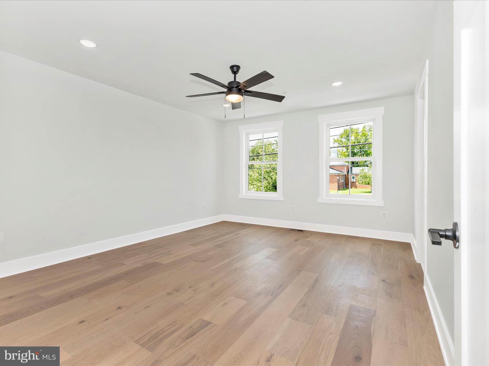 252 South Carroll Street Frederick, MD 21701 - Photo 41 of 68 an empty room with wooden floor ceiling fan and windows