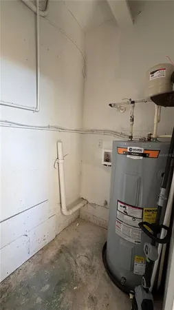 a room with water heater and wooden cabinets