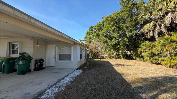 a view of a house with backyard and trees