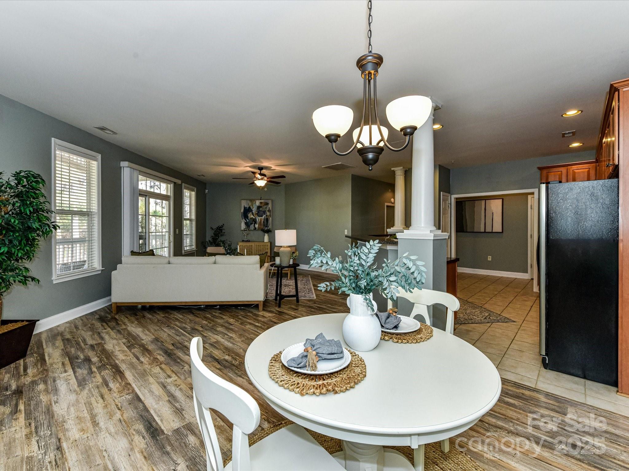 9065 Rosalyn Glen Road Cornelius, NC 28031 - Photo 10 of 35 a dining room with wooden floor a chandelier a wooden table and chairs
