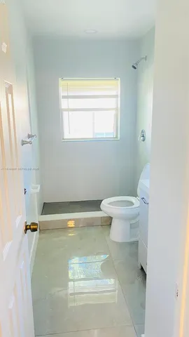 a bathroom with a sink a toilet and a window