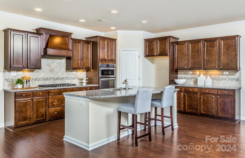 2233 Millenium Drive, Unit 13 Lancaster, SC 29720 - Photo 6 of 15 a kitchen with stainless steel appliances granite countertop wooden cabinets a refrigerator and a stove top oven