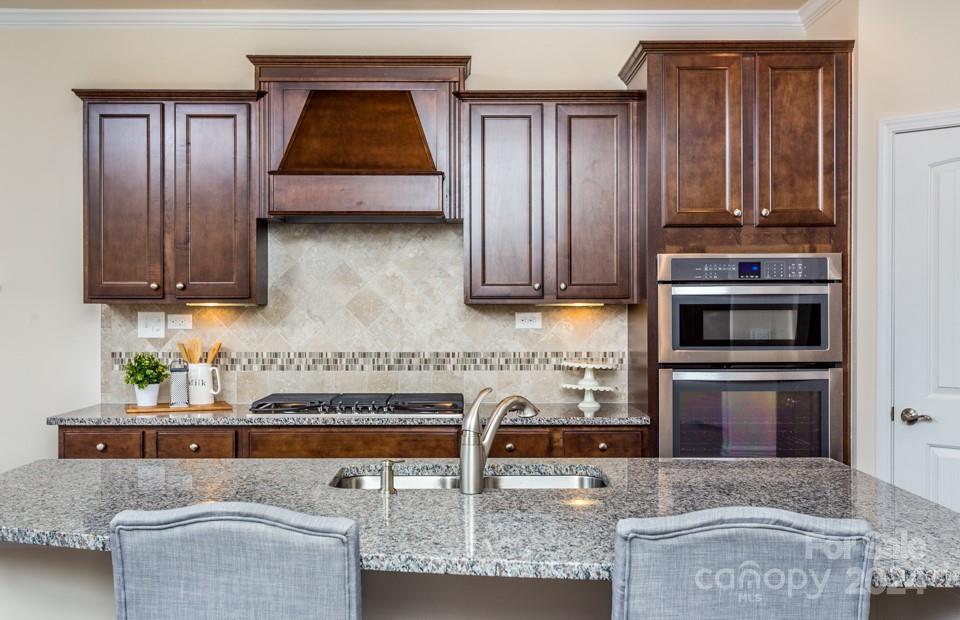 2233 Millenium Drive, Unit 13 Lancaster, SC 29720 - Photo 7 of 15 a kitchen with stainless steel appliances granite countertop a stove and a microwave