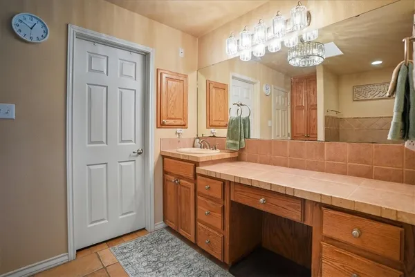 a spacious bathroom with a granite countertop sink a mirror and a shower