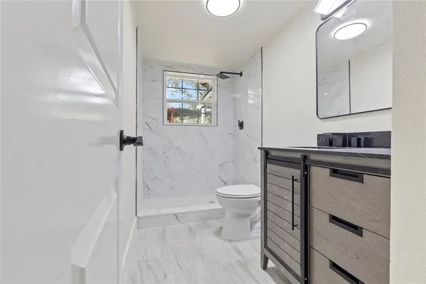 a bathroom with a toilet sink and a mirror