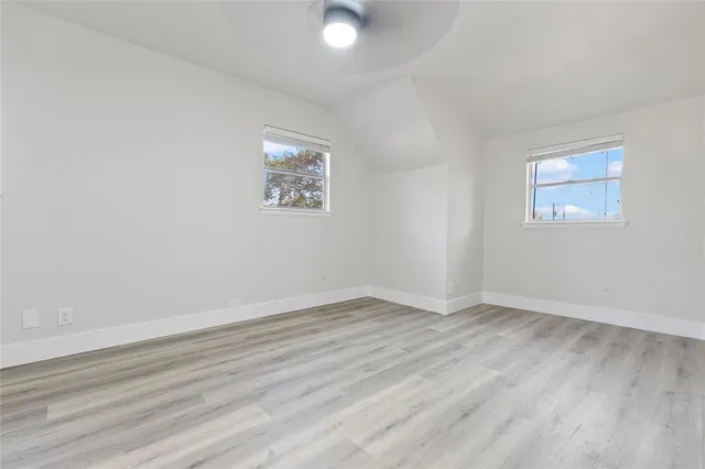 an empty room with wooden floor and window