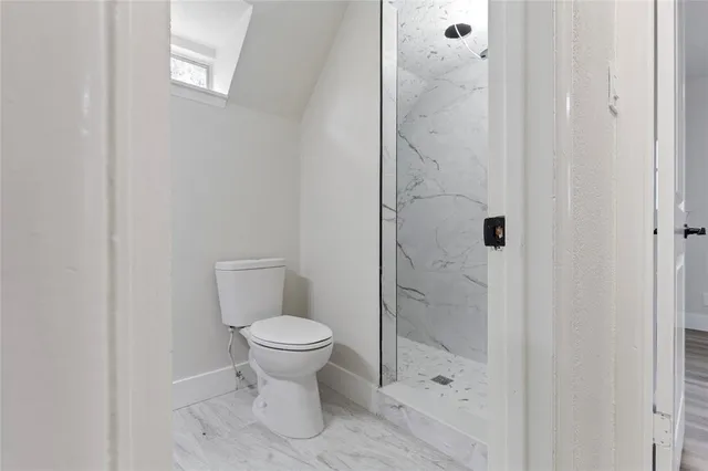 a bathroom with a toilet and a shower