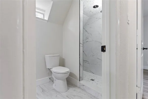 a bathroom with a toilet and a shower