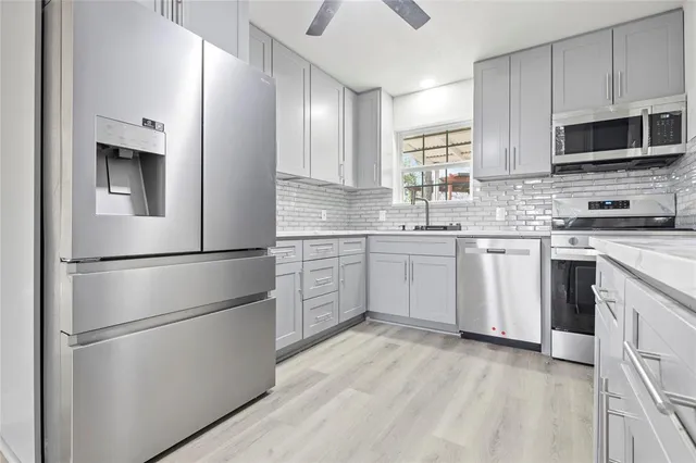 a kitchen with stainless steel appliances a refrigerator sink and microwave