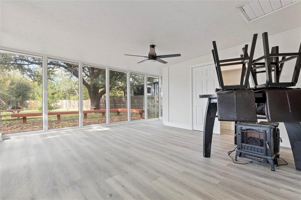 706 Commerce Street Euless, TX 76040 - Photo 5 of 28 a view of an empty room with wooden floor windows and a wooden floor