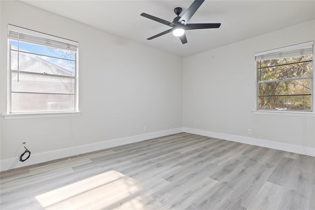 706 Commerce Street Euless, TX 76040 - Photo 9 of 28 a view of an empty room with a window and wooden floor