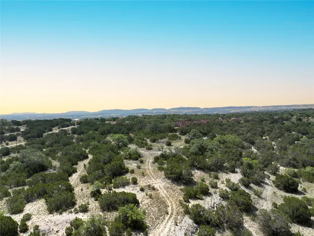 an aerial view of house with yard and mountain view in back