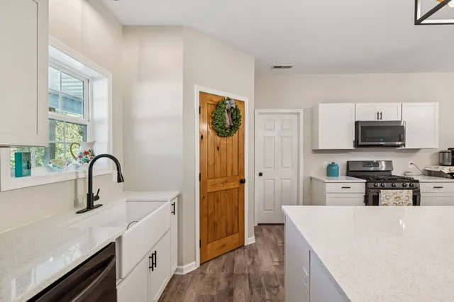 a kitchen with stainless steel appliances a white stove top oven a sink dishwasher and a refrigerator