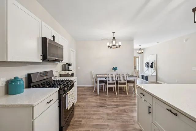 a kitchen with stainless steel appliances granite countertop a stove a microwave and a refrigerator