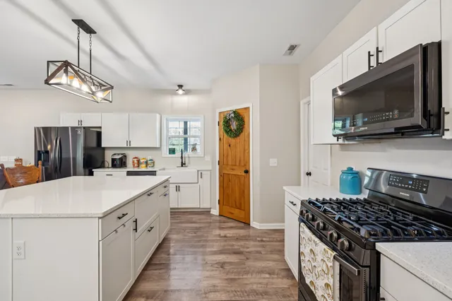a kitchen with appliances a sink and a window