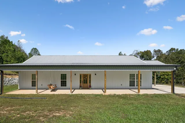 a front view of a house with a garden and yard