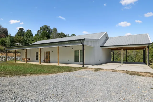 a front view of a house with a yard and trees
