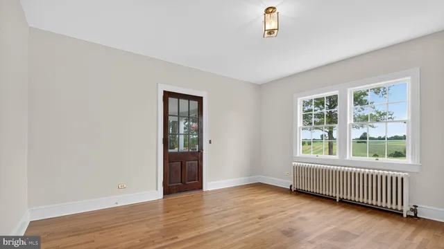 wooden floor fireplace and windows in an empty room