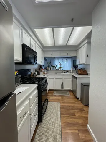 a view of an empty room with wooden floor and stairs