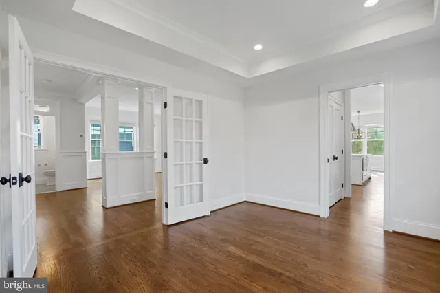 a view of a big room with wooden floor and windows