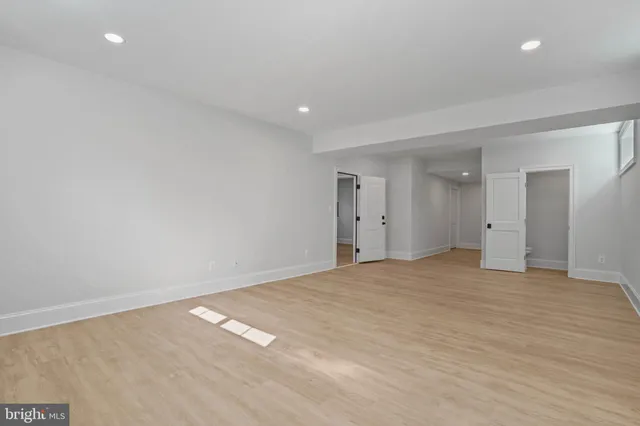 a large kitchen with a refrigerator a stove a microwave and a wooden floor