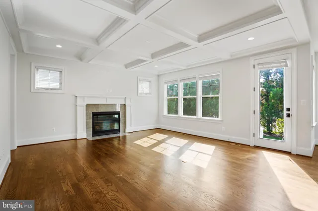 an empty room with large windows and a fireplace