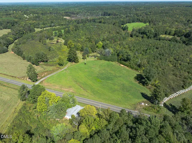 an aerial view of residential houses with outdoor space and trees