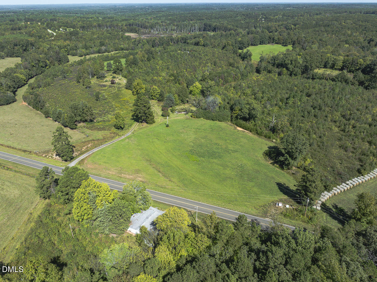 an aerial view of residential houses with outdoor space and trees