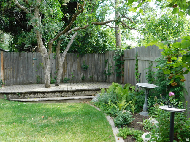 2148 Carolyn Way Bountiful, UT 84010 - Photo 31 of 40 Expansive yard featuring a tiered wood deck, mature trees, manicured lawn, garden beds, and wood privacy fencing