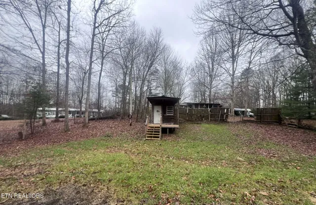 a backyard of a house with table and chairs