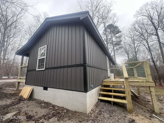 a view of a house with a yard and wooden fence