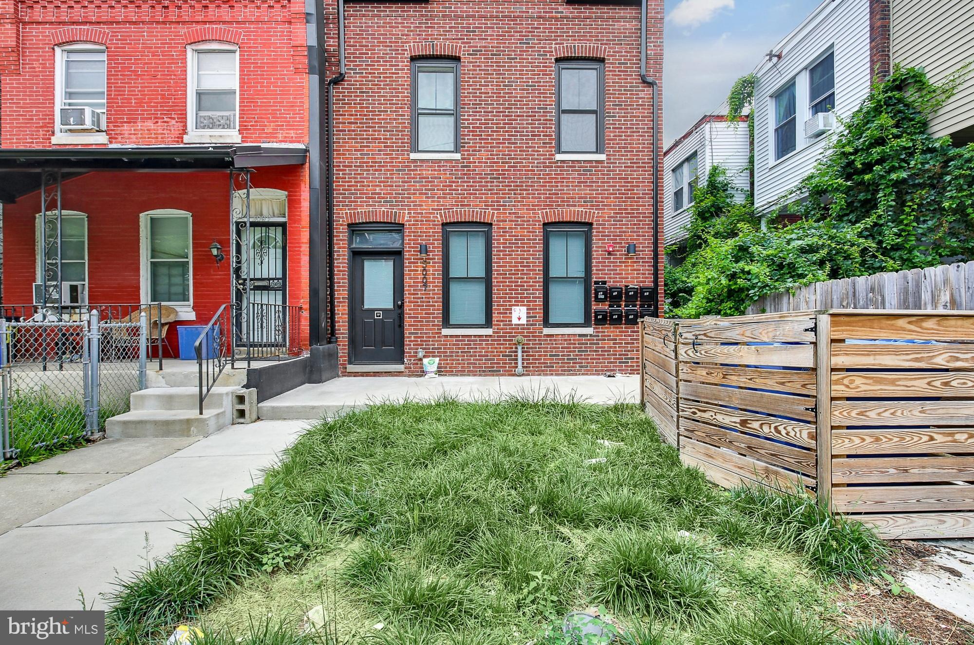 5007 Pentridge Street, Unit 1C Philadelphia, PA 19143 - Photo 14 of 14 a view of a building with a backyard and sitting area