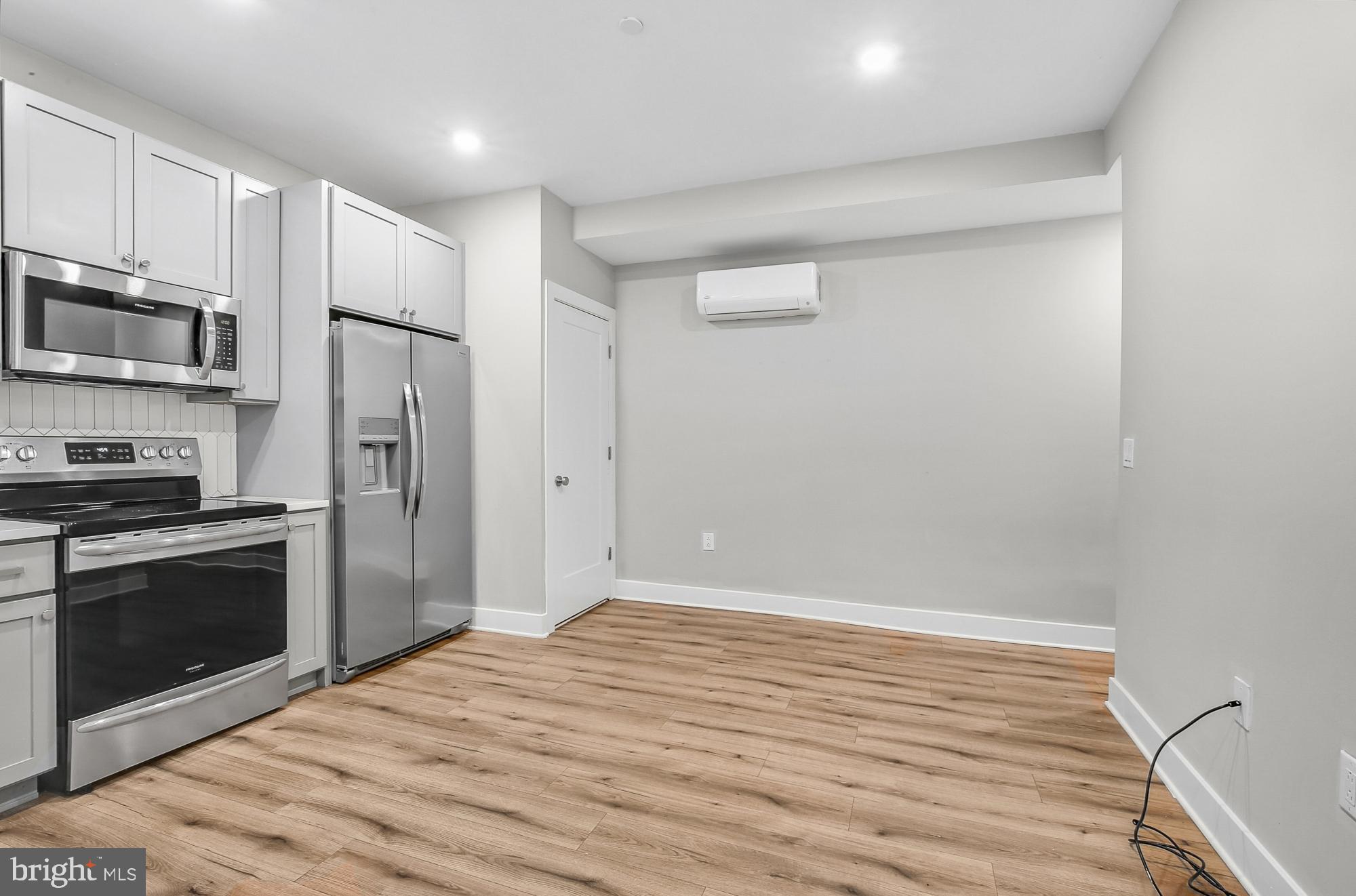 5007 Pentridge Street, Unit 1C Philadelphia, PA 19143 - Photo 2 of 14 a kitchen with stainless steel appliances a refrigerator and a stove top oven