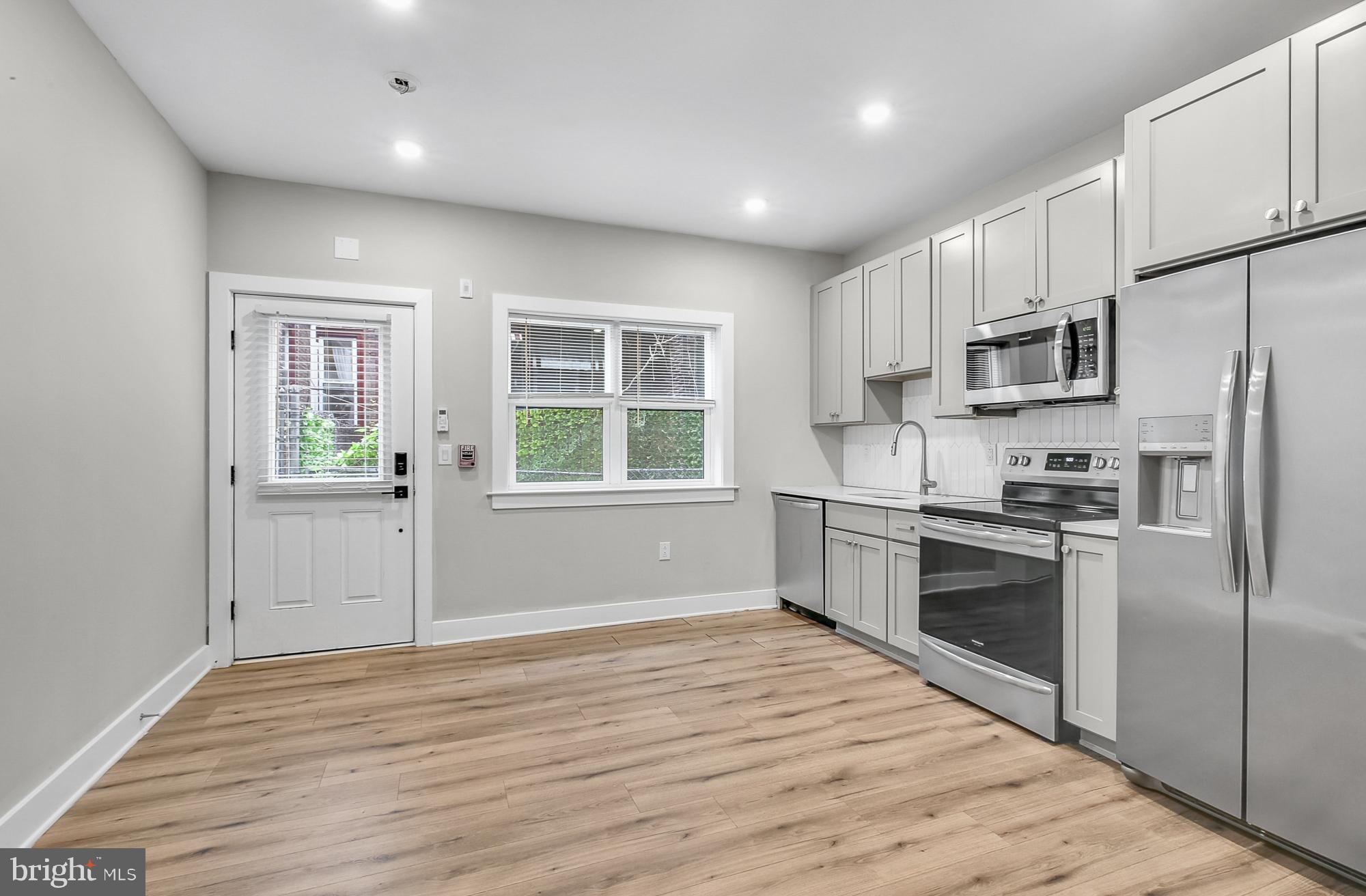 5007 Pentridge Street, Unit 1C Philadelphia, PA 19143 - Photo 4 of 14 a kitchen with stainless steel appliances a refrigerator sink and stove