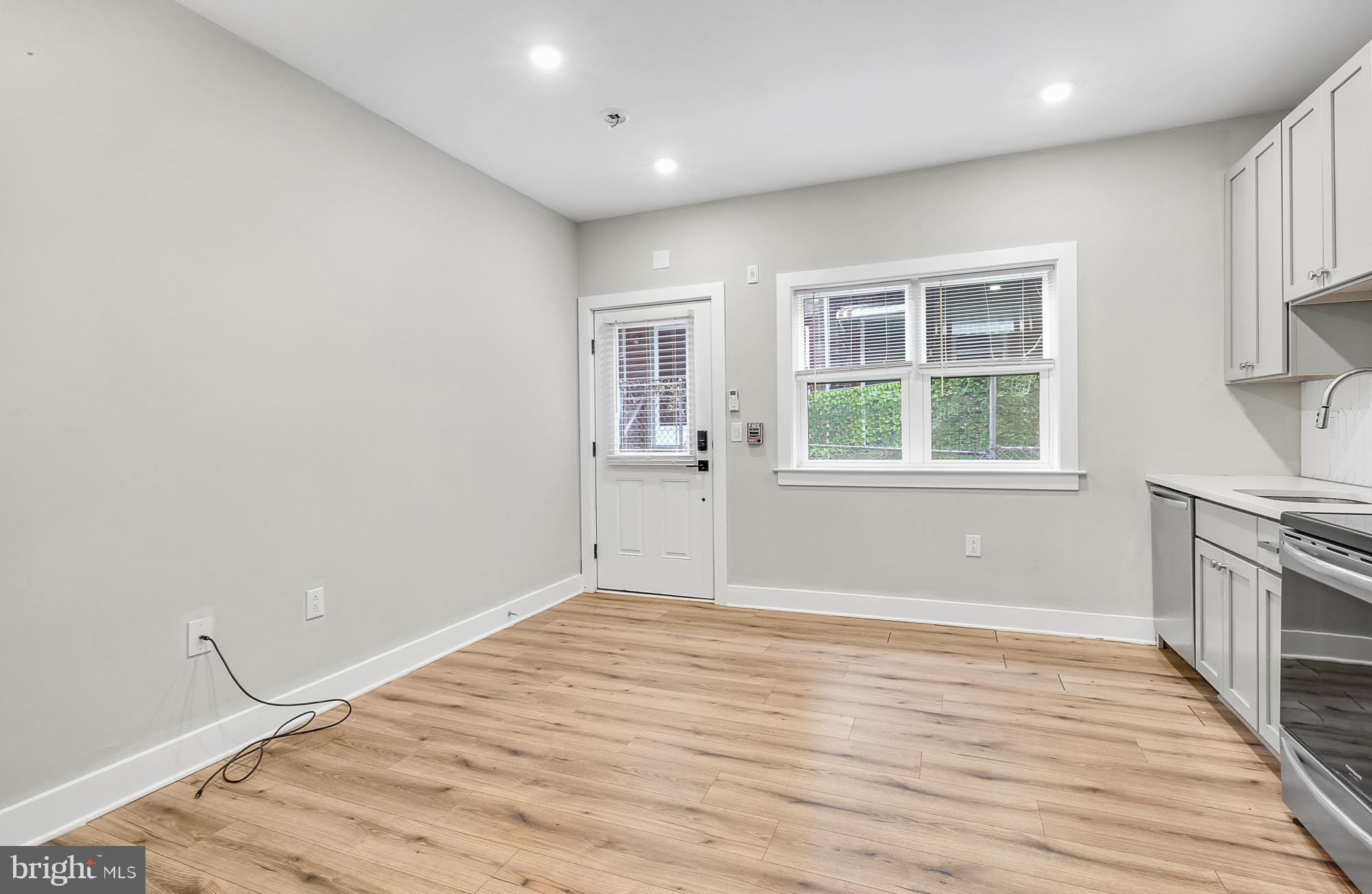 5007 Pentridge Street, Unit 1C Philadelphia, PA 19143 - Photo 5 of 14 wooden floor in an empty room with a window