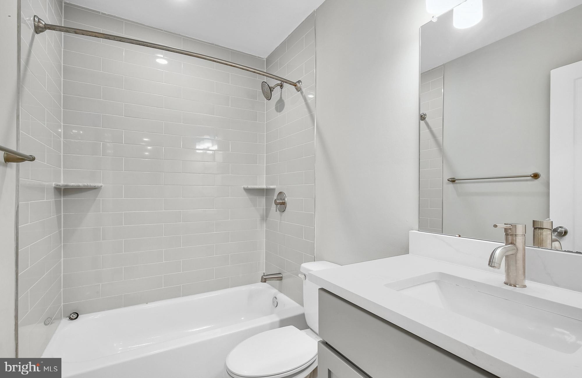 5007 Pentridge Street, Unit 1C Philadelphia, PA 19143 - Photo 8 of 14 a bathroom with a granite countertop sink toilet and shower