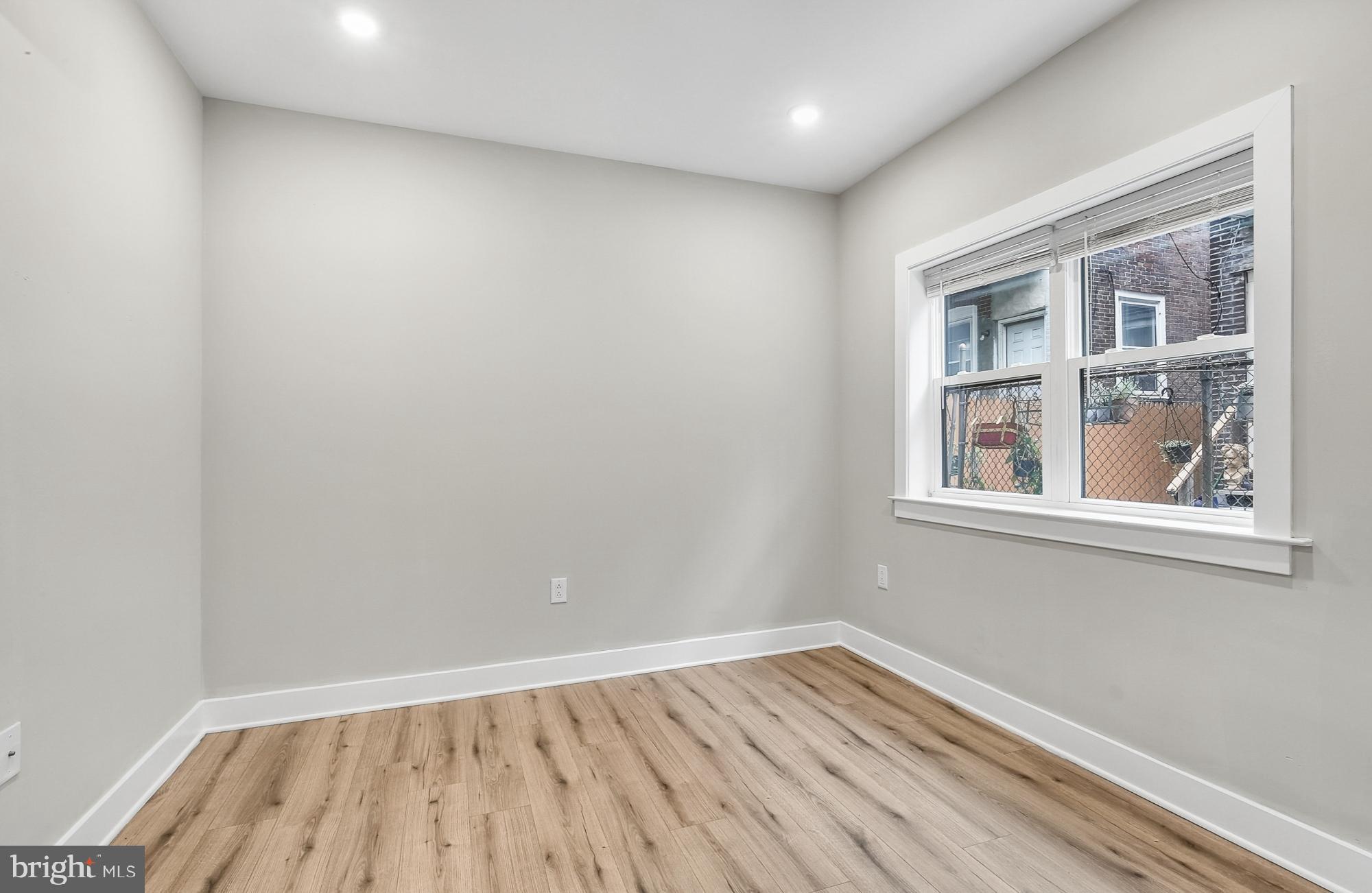 5007 Pentridge Street, Unit 1C Philadelphia, PA 19143 - Photo 9 of 14 an empty room with wooden floor and windows